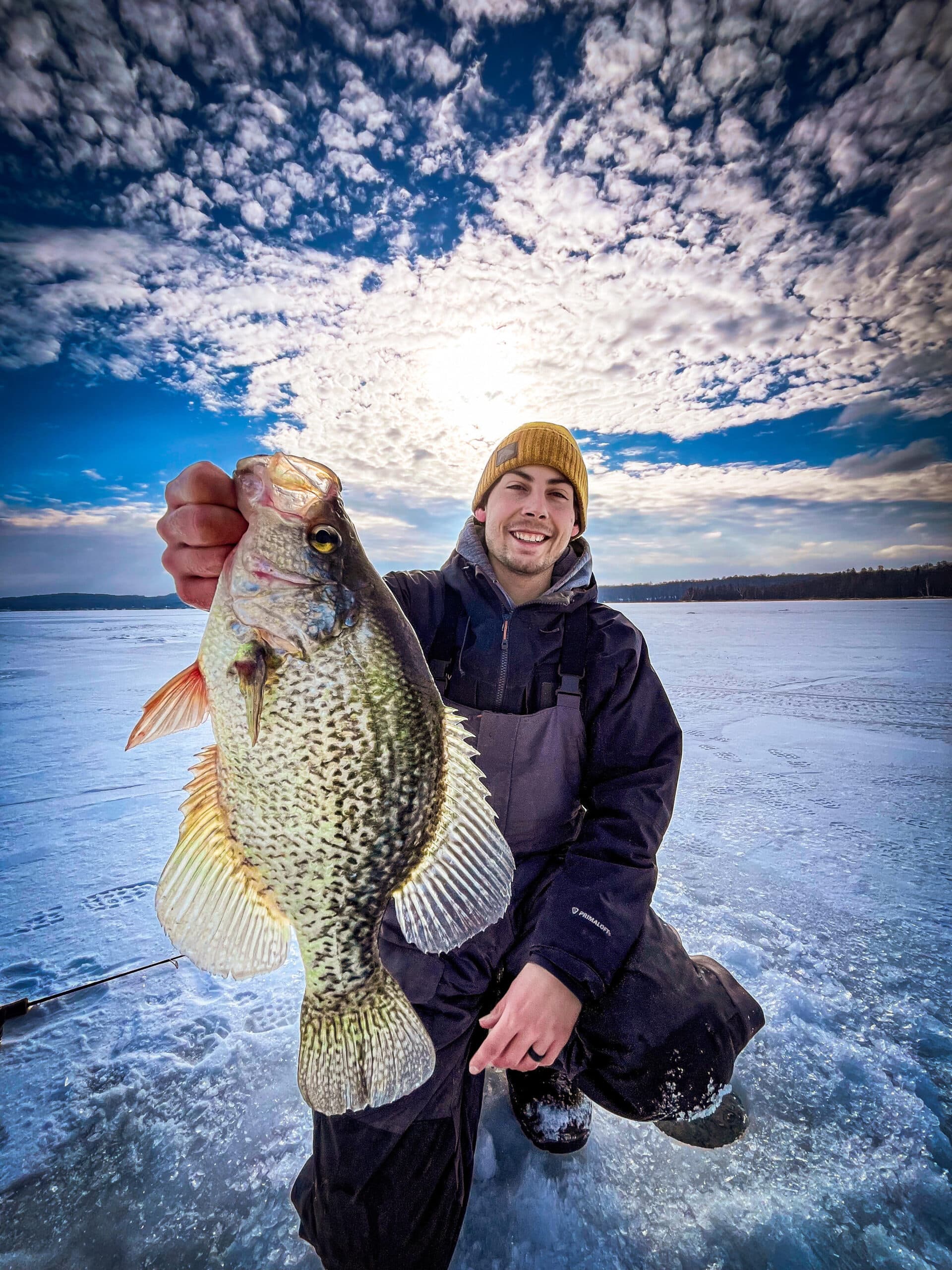 Winter fishing on frozen lake man in bobble hat Vector Image